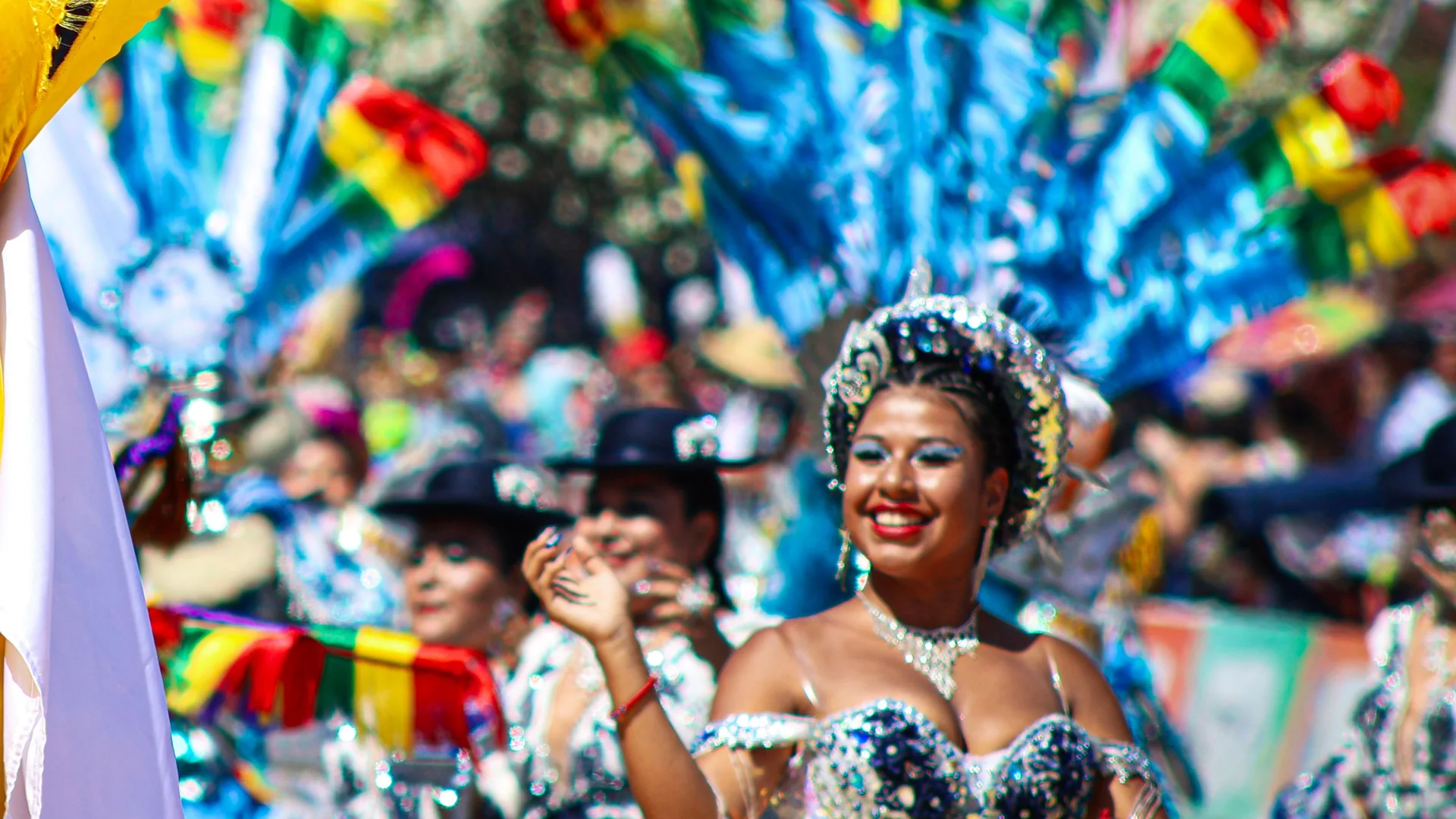 A dancer in a sequinned costume and silver headdress smiling at a Chilean folk-dance carnival, representative of the country's folklore tradition